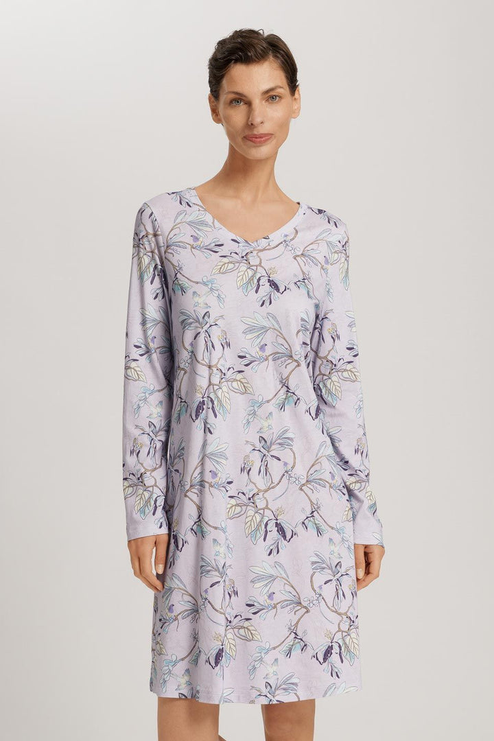 Woman wearing a floral patterned nightshirt on a plain background