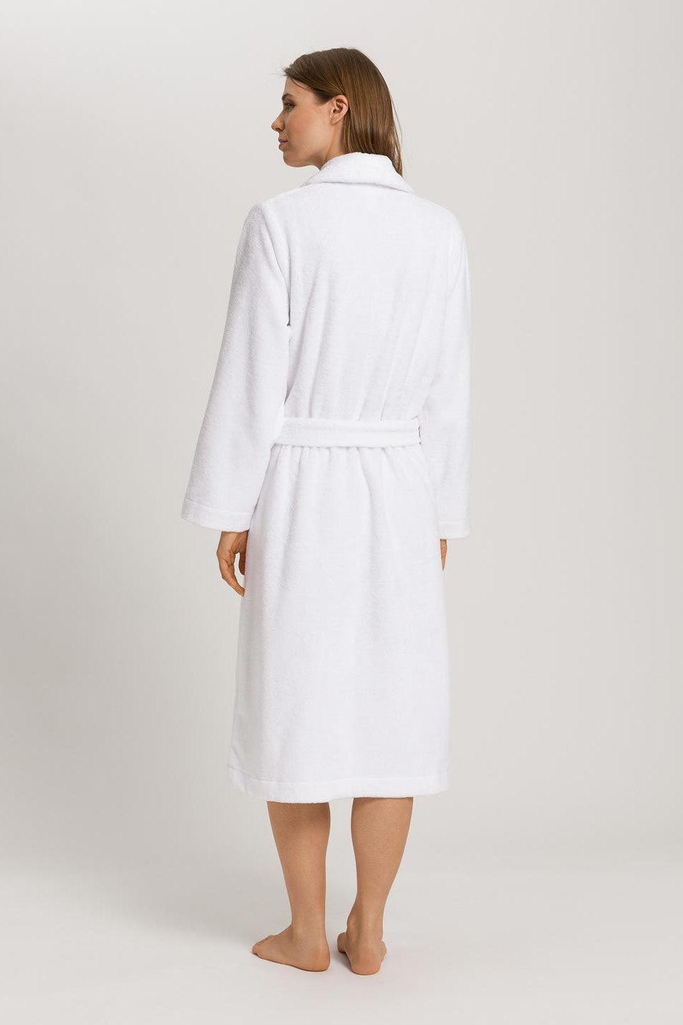 Woman wearing a white robe on a plain background
