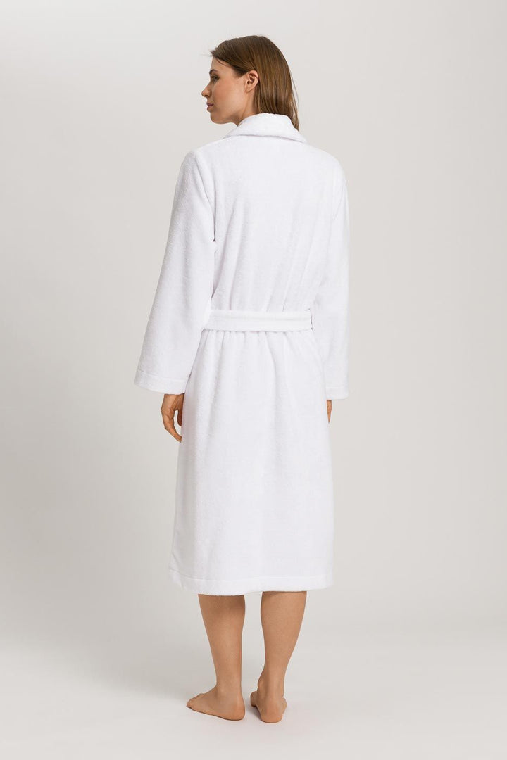 Woman wearing a white robe on a plain background