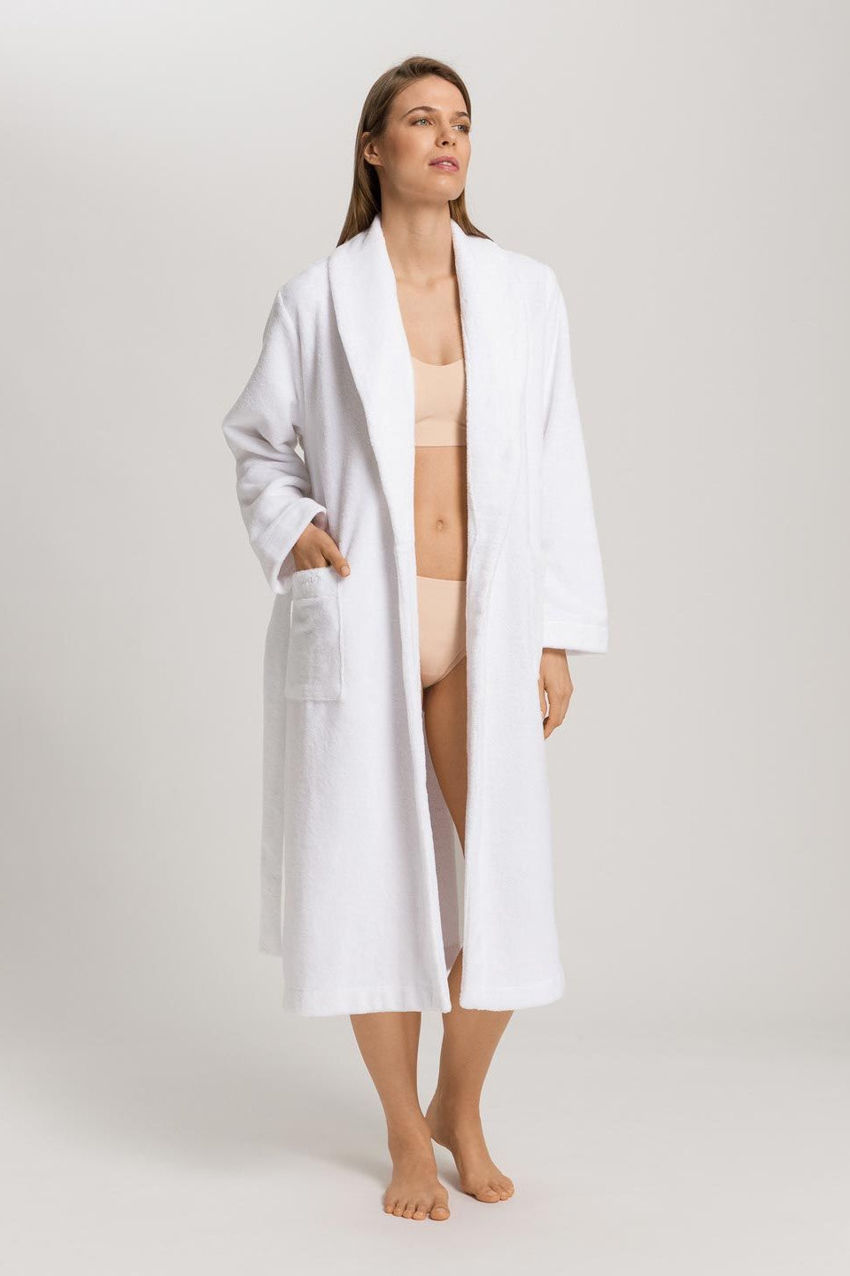 Woman wearing a white robe on a plain background