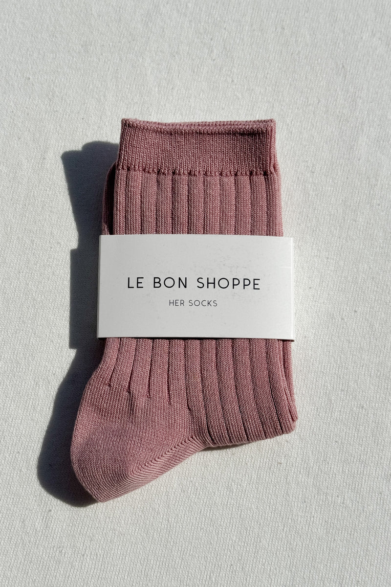 Pair of pink socks with a 'Le Bon Shoppe' label on a light gray background