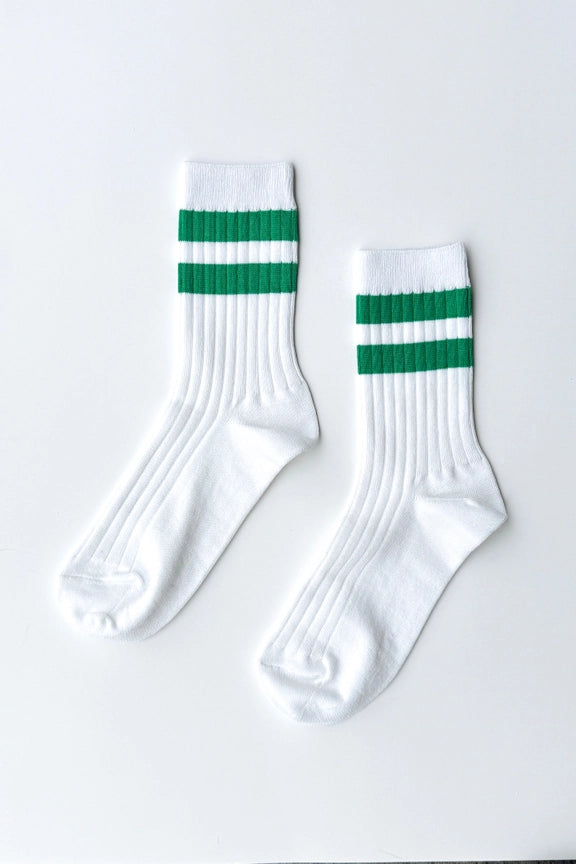 White socks with green stripes on a light gray background