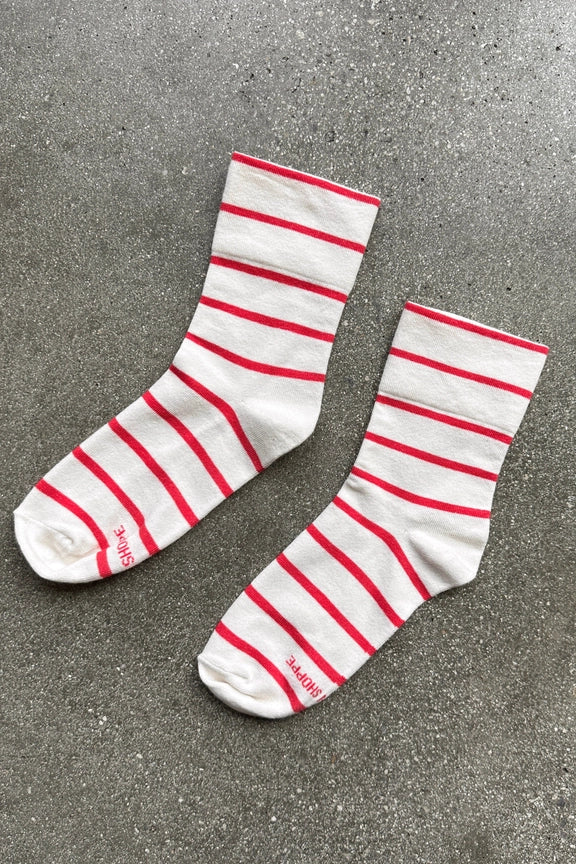 White socks with red stripes on a gray concrete surface
