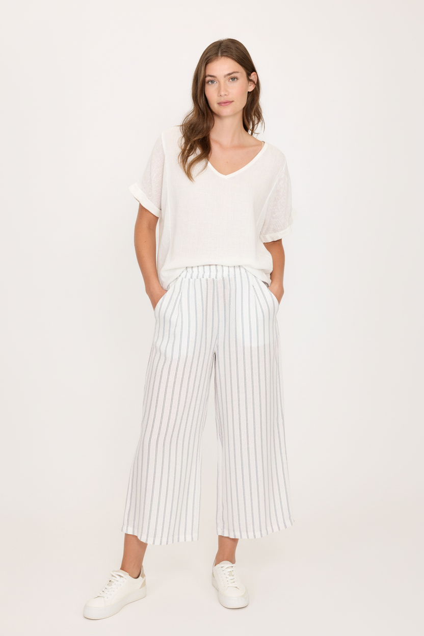 A model wearing a linen t-shirt and striped linen croppped pant. Perfect for hot weather, vacations or as swim coverups.