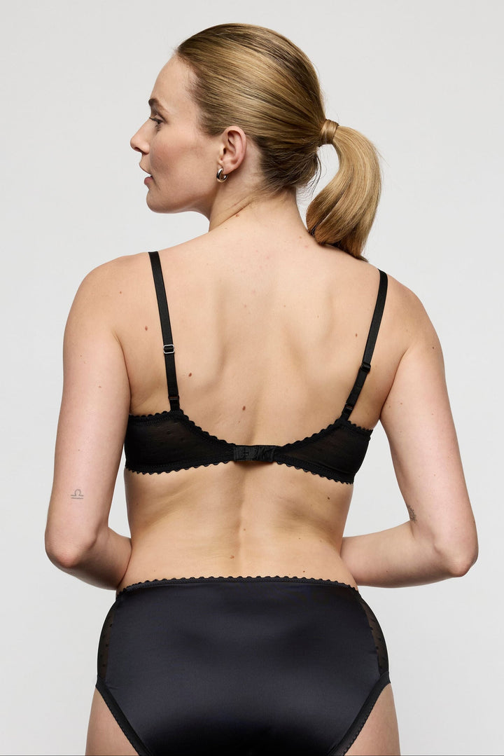 woman wearing the Marie Jo Noova Half Padded Balcony Bra with the matching full brief.  Printed bows on mesh lace with pink floral edges and half padded. Comfortable and gorgeous set with sexy boudoir look. 