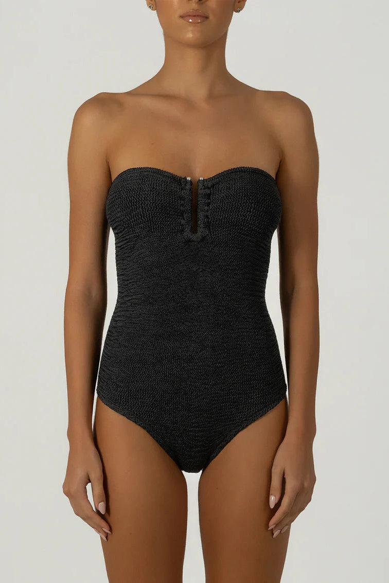 Black strapless swimsuit worn by a model on a white background