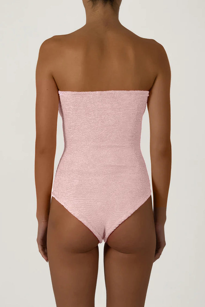 Pink strapless swimsuit worn by a model on a plain background