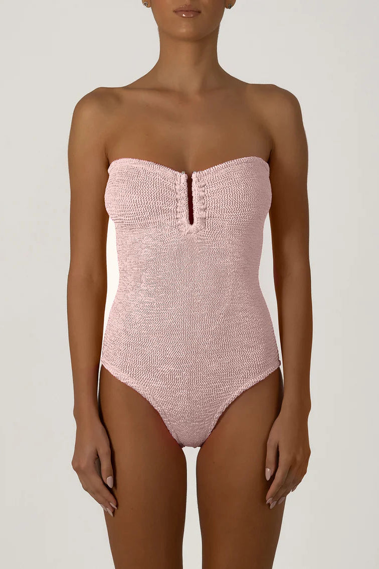 Pink strapless swimsuit worn by a model on a plain background