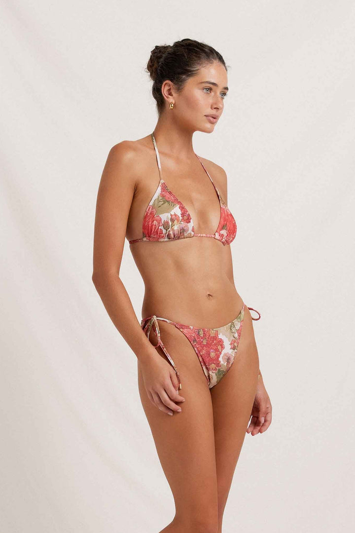 Woman wearing a floral bikini against a plain background