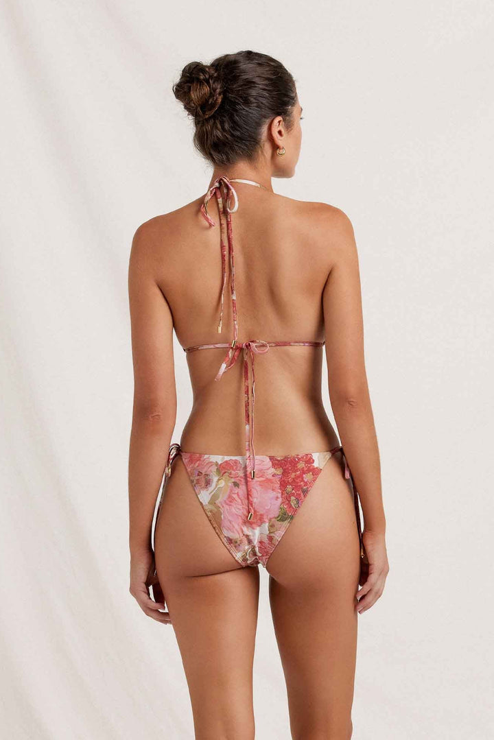 Woman wearing a floral bikini against a plain background