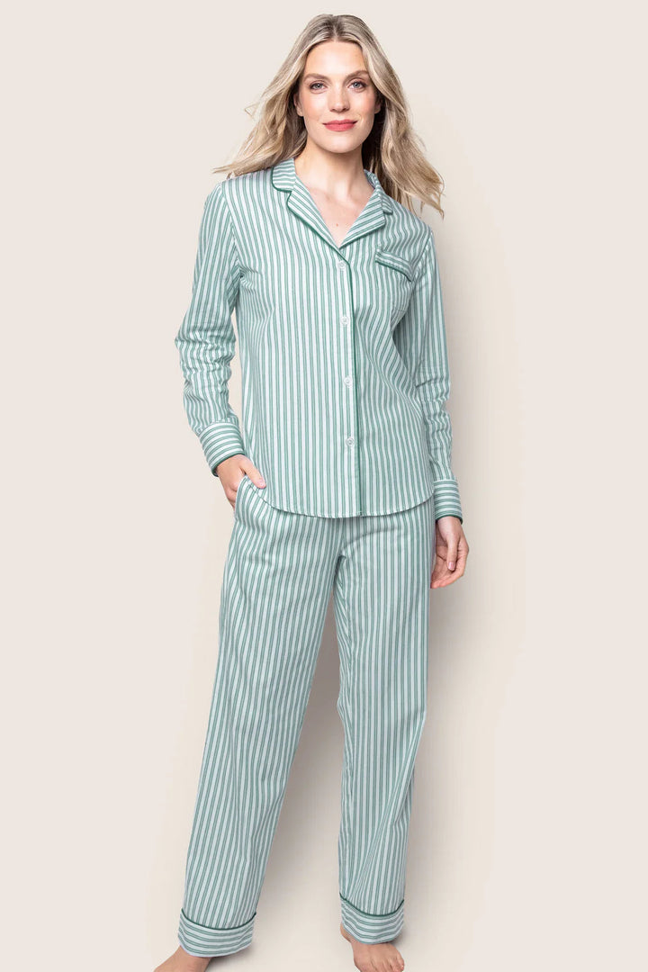 Woman wearing a green and white striped pajama set against a beige background