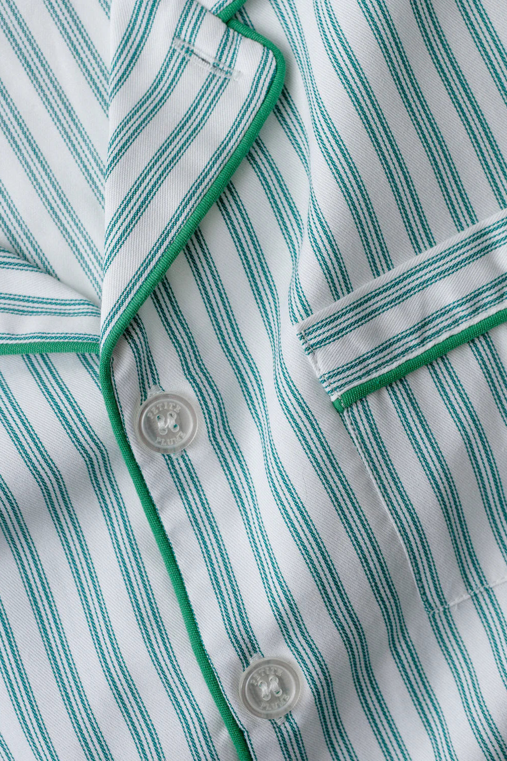 Close-up of a green and white striped shirt with buttons.