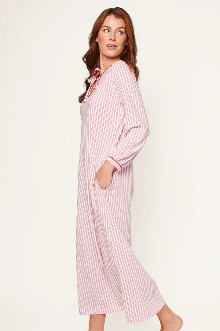 Woman wearing a pink and white striped nightshirt against a plain background
