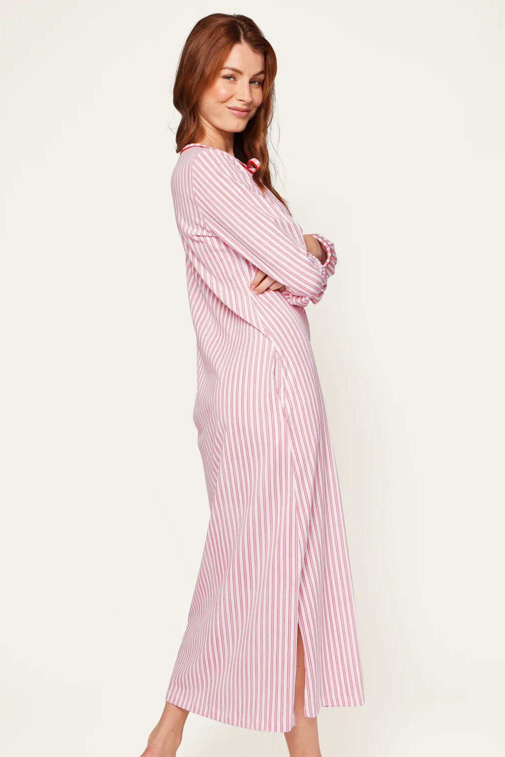 Woman wearing a red and white striped dress on a plain background