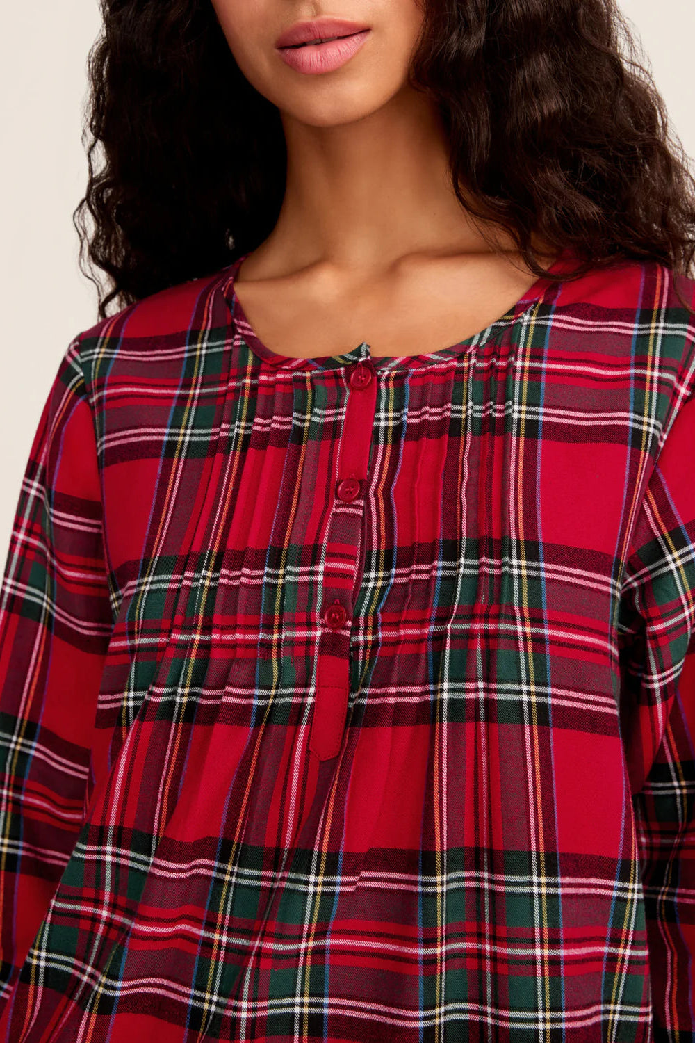 Red plaid shirt worn by a person on a plain background