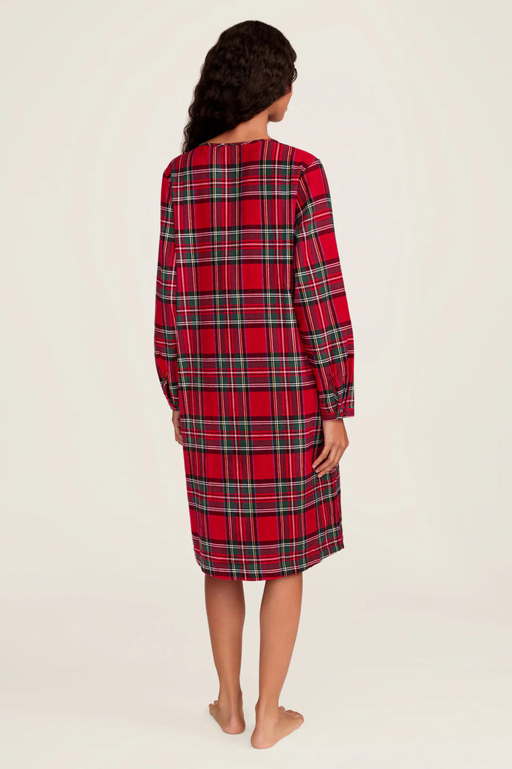 Person wearing a red plaid nightshirt on a plain background
