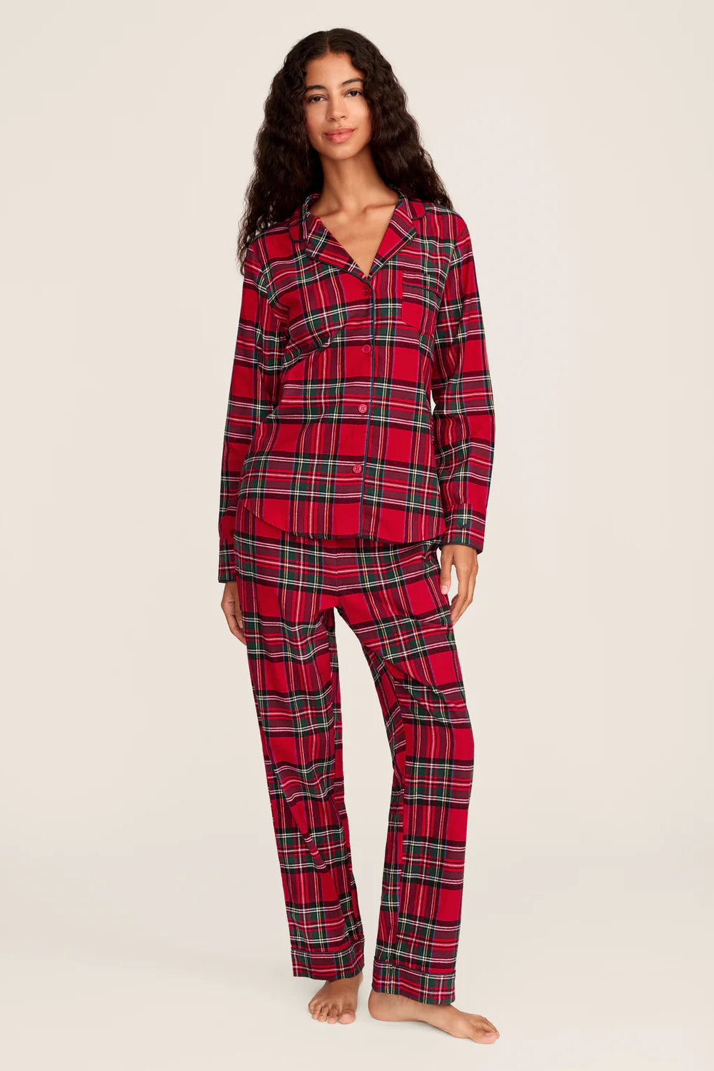 Woman wearing red plaid pajamas on a beige background