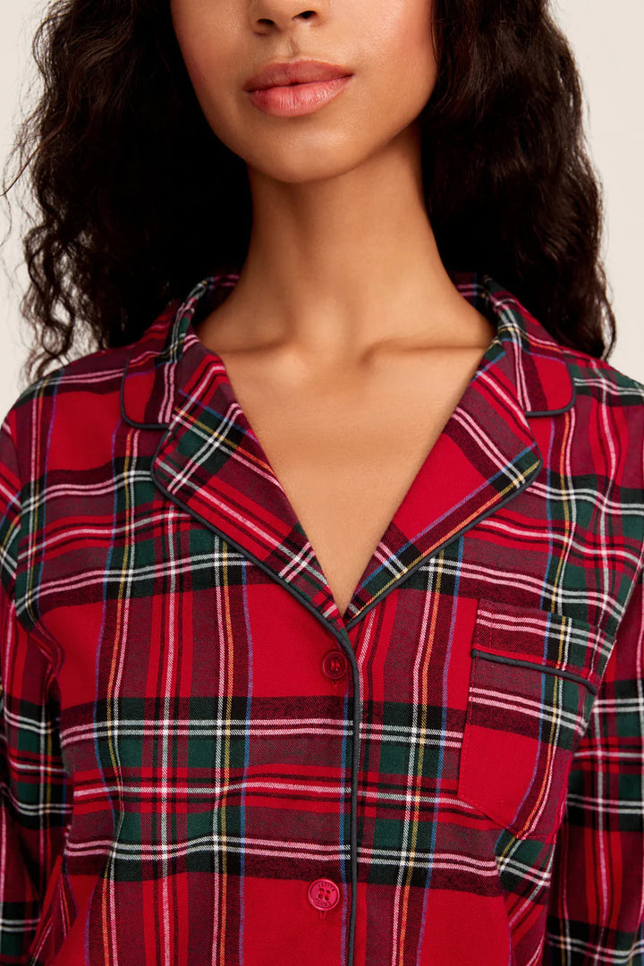 Red plaid shirt worn by a person on a plain background