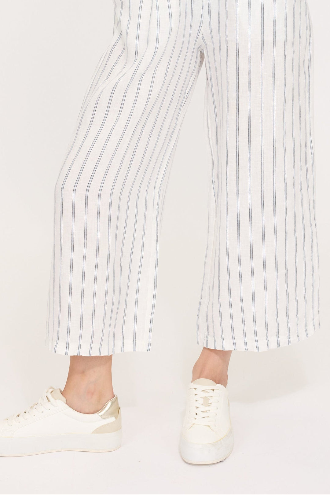 A model wearing a linen t-shirt and striped linen croppped pant. Perfect for hot weather, vacations or as swim coverups.