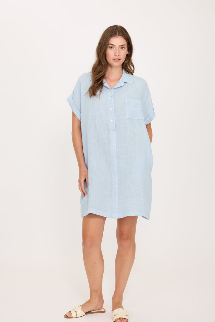 Woman wearing a light blue linen dress on a white background. Comfortable and breathable summer dress.