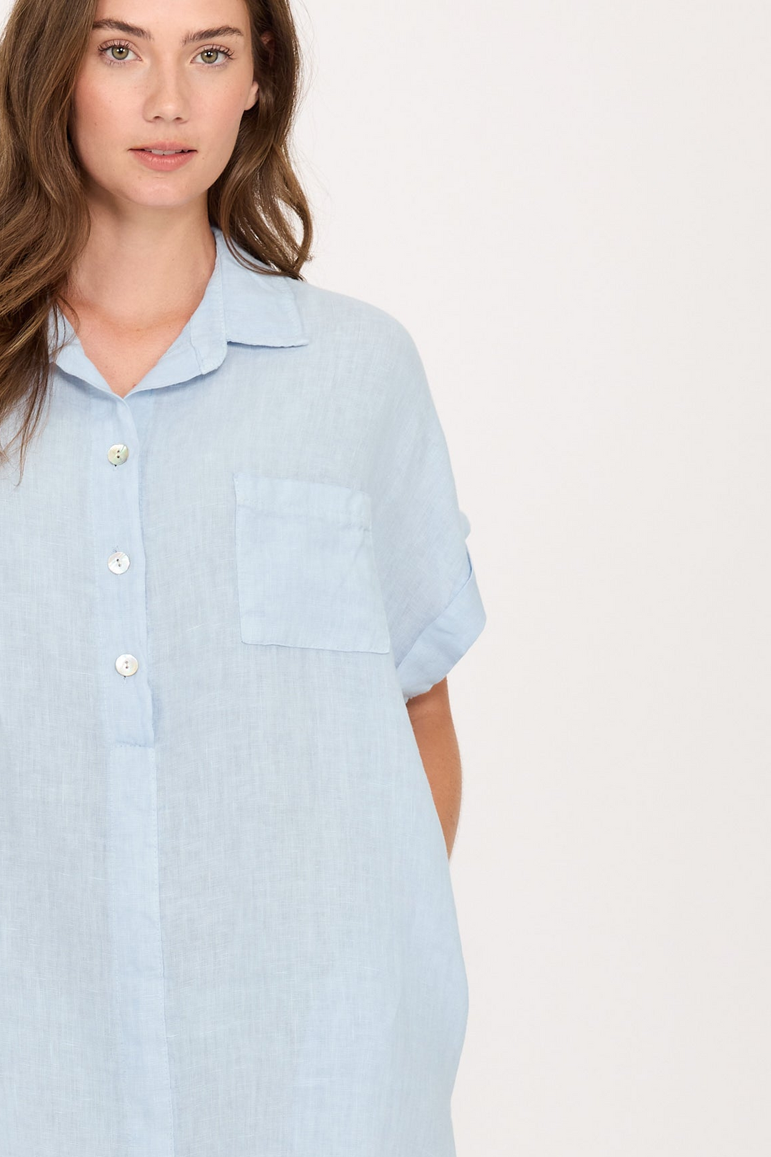 Light blue linen dress with buttons and pocket detail.