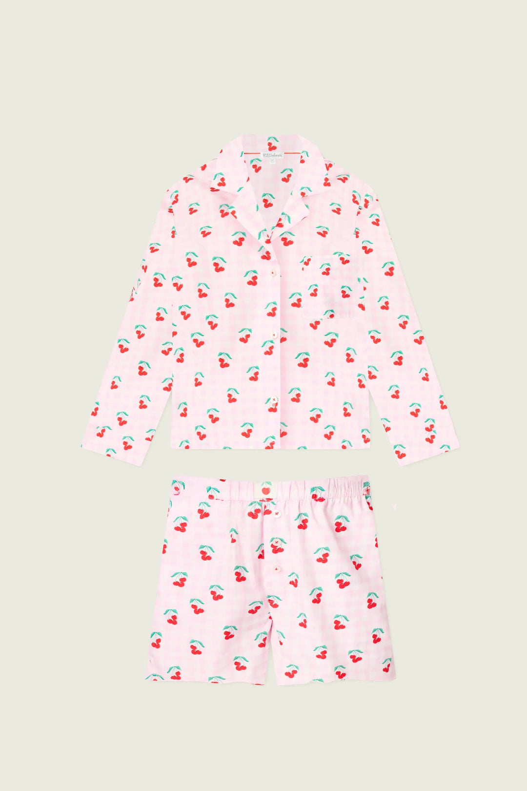 Pink pajama set with cherry pattern on a light gray background