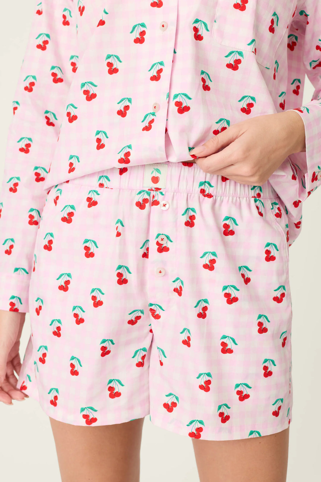 Pink pajama set with cherry pattern on a plain background