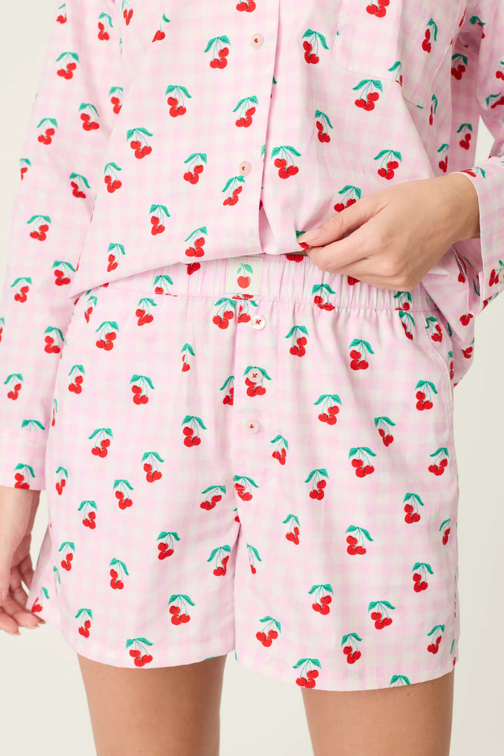 Pink pajama set with cherry pattern on a plain background