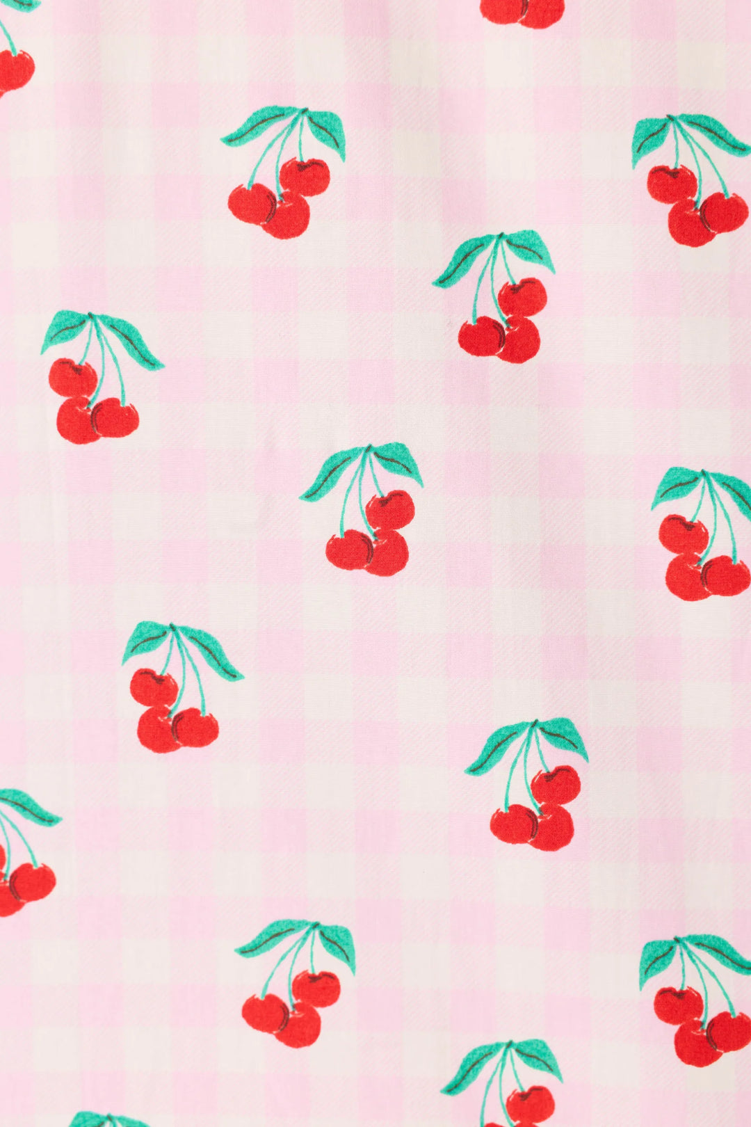 Pattern of red cherries with green leaves on a pink background