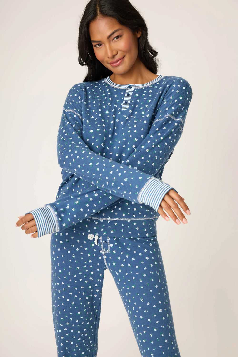 Woman wearing a blue floral pajama set against a plain background