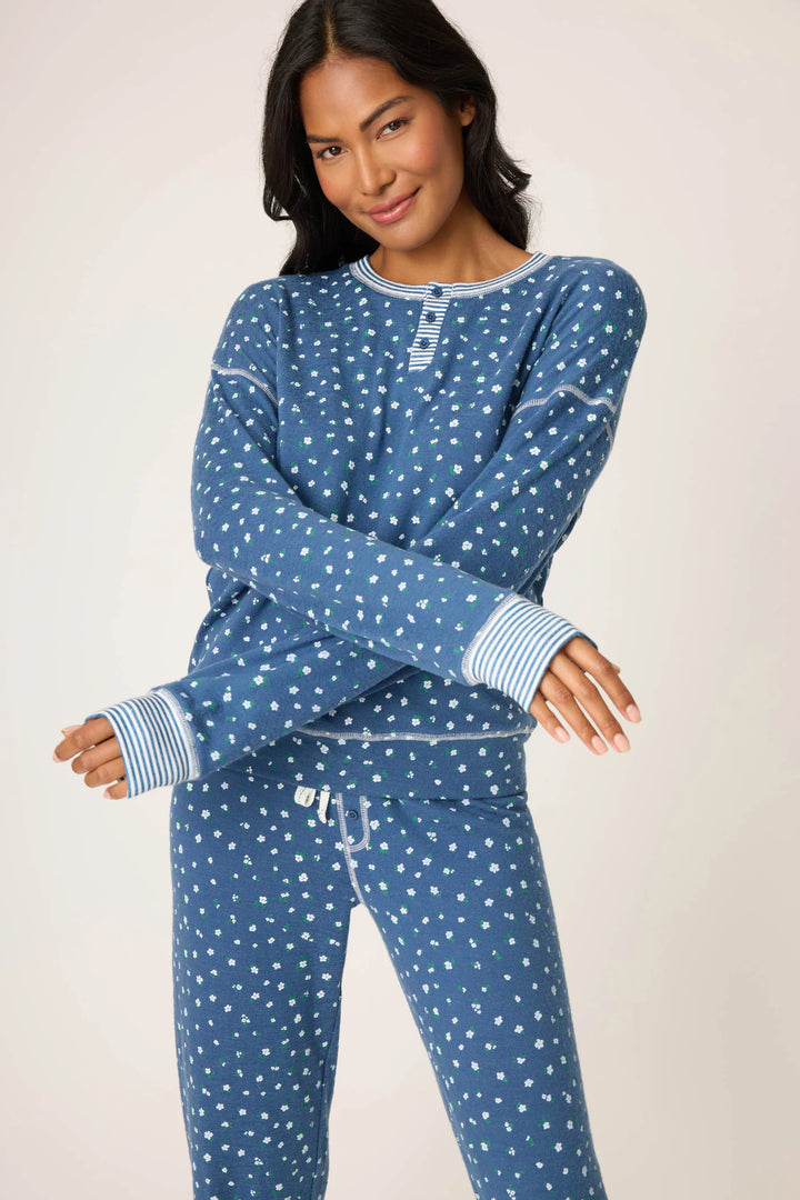 Woman wearing a blue floral pajama set against a plain background