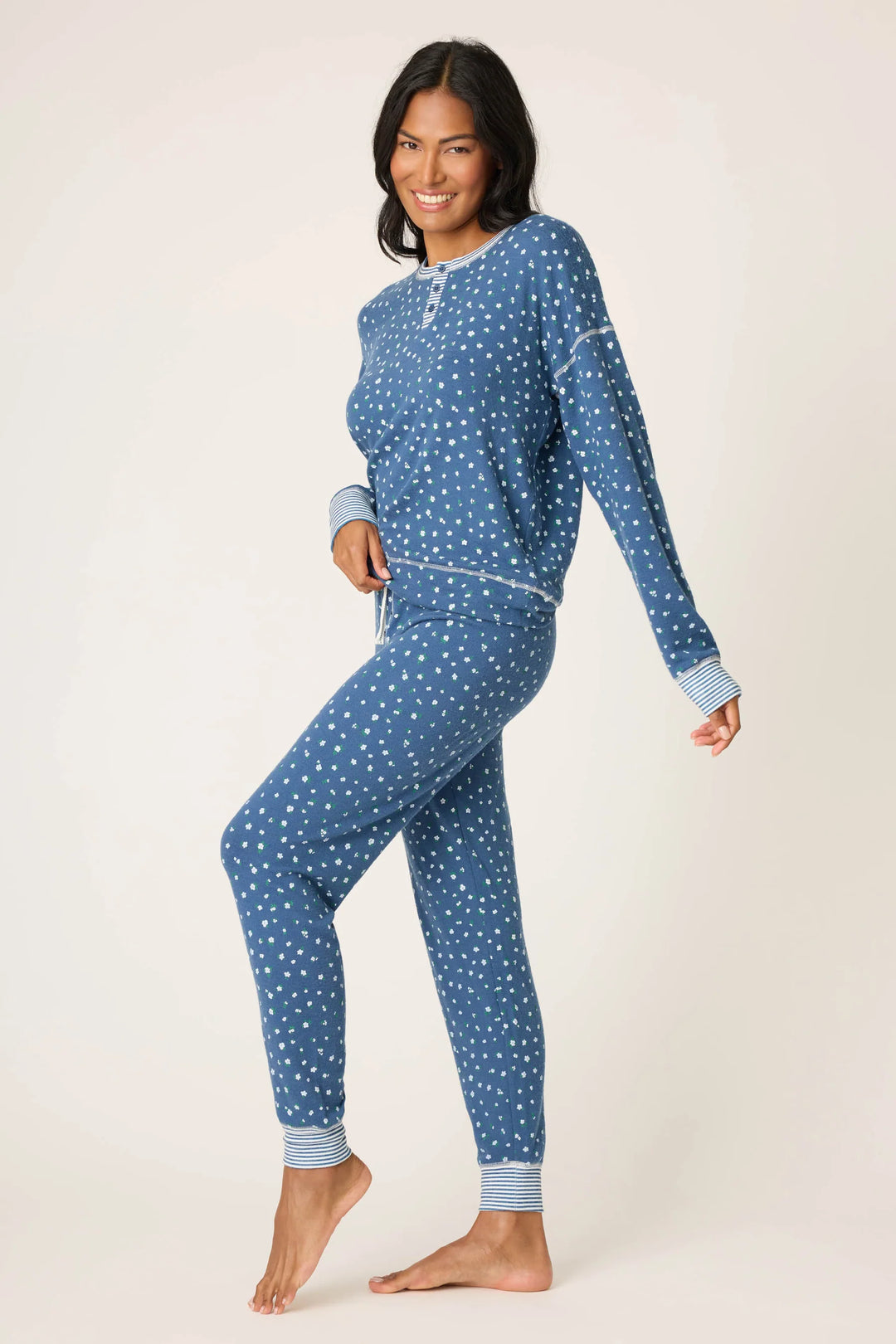 Woman wearing a blue floral pajama set on a white background