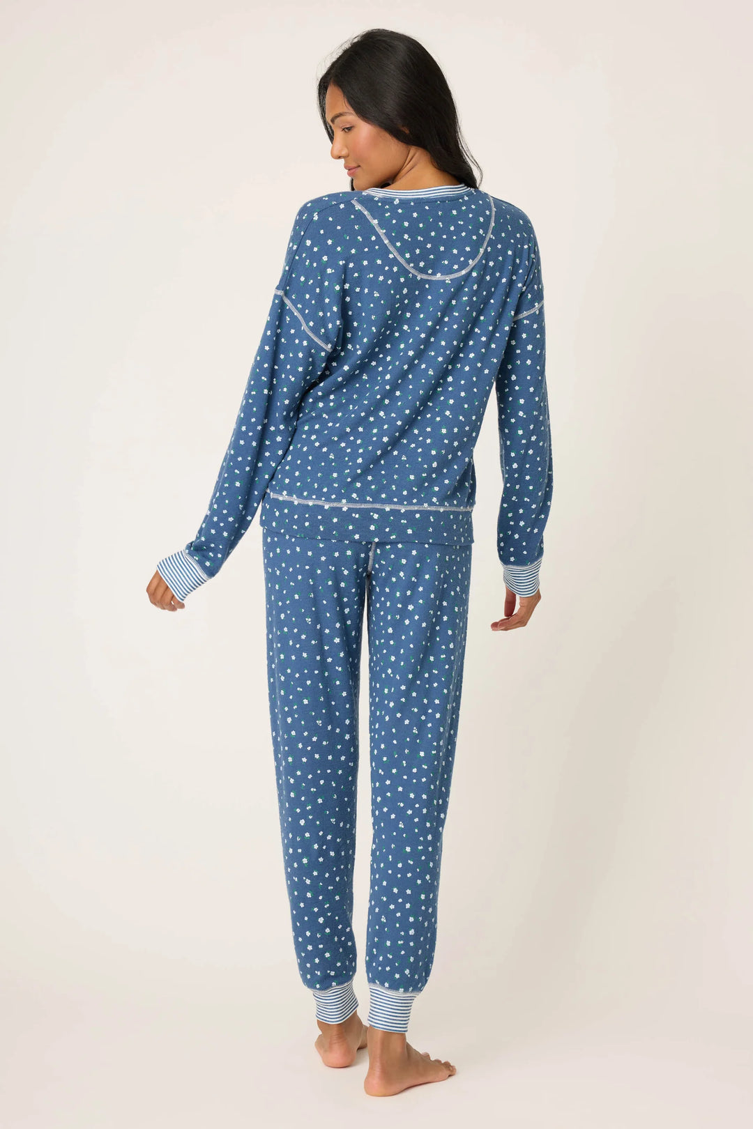 Woman wearing a blue floral pajama set on a white background