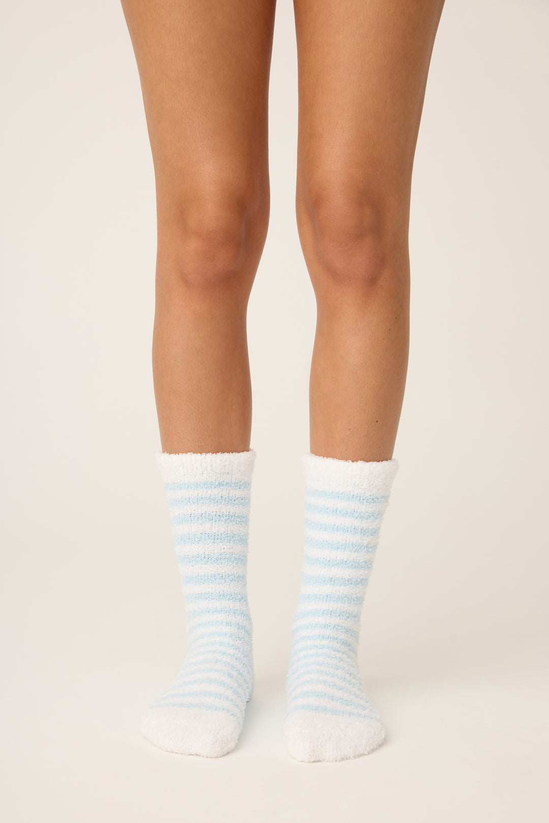 Striped socks worn by a person on a plain background