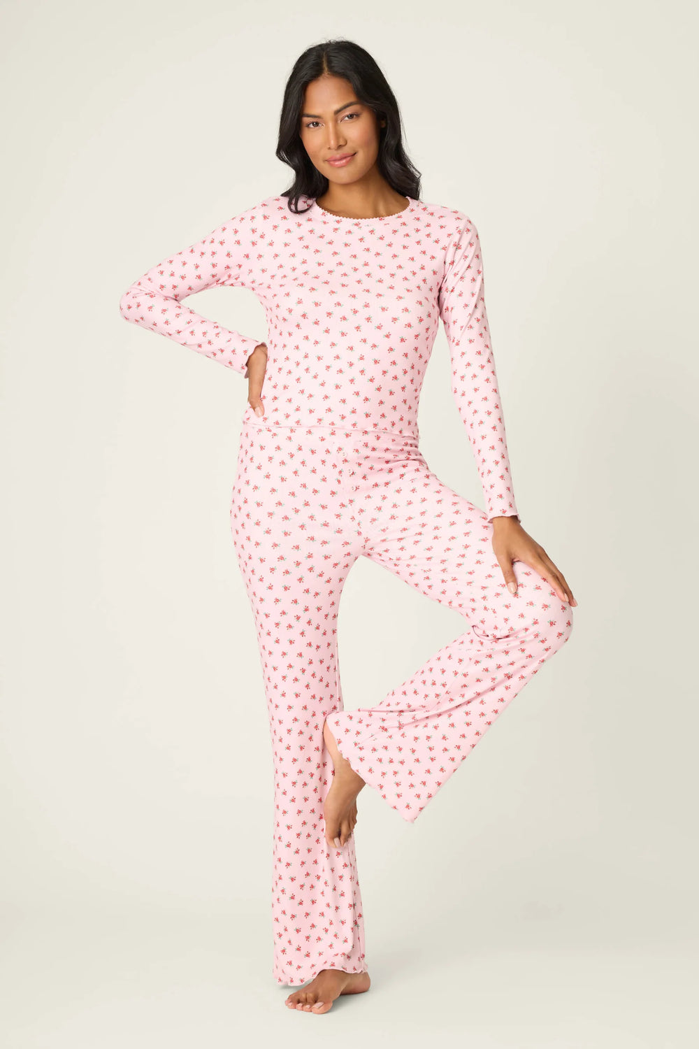 Woman wearing a pink polka dot pajama set on a white background