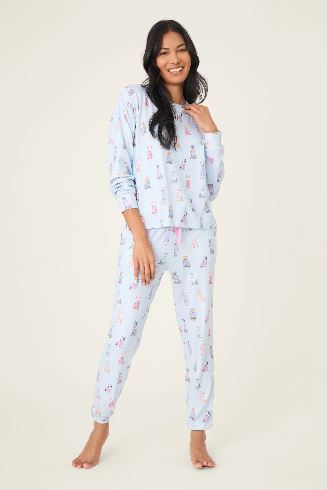 Woman wearing a light blue pajama set with animal prints on a white background