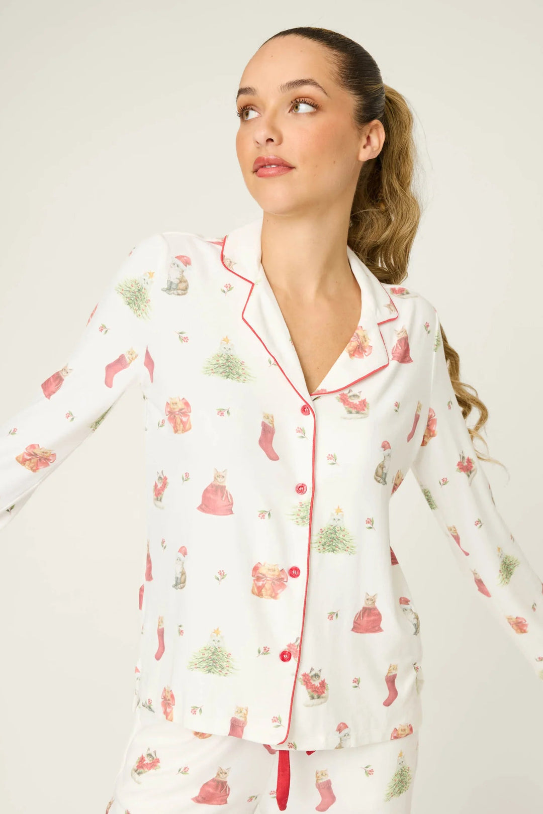 Woman wearing a floral pajama set against a plain background