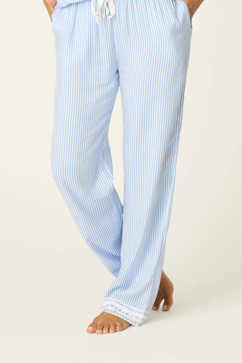 Woman wearing a light blue pajama set on a white background