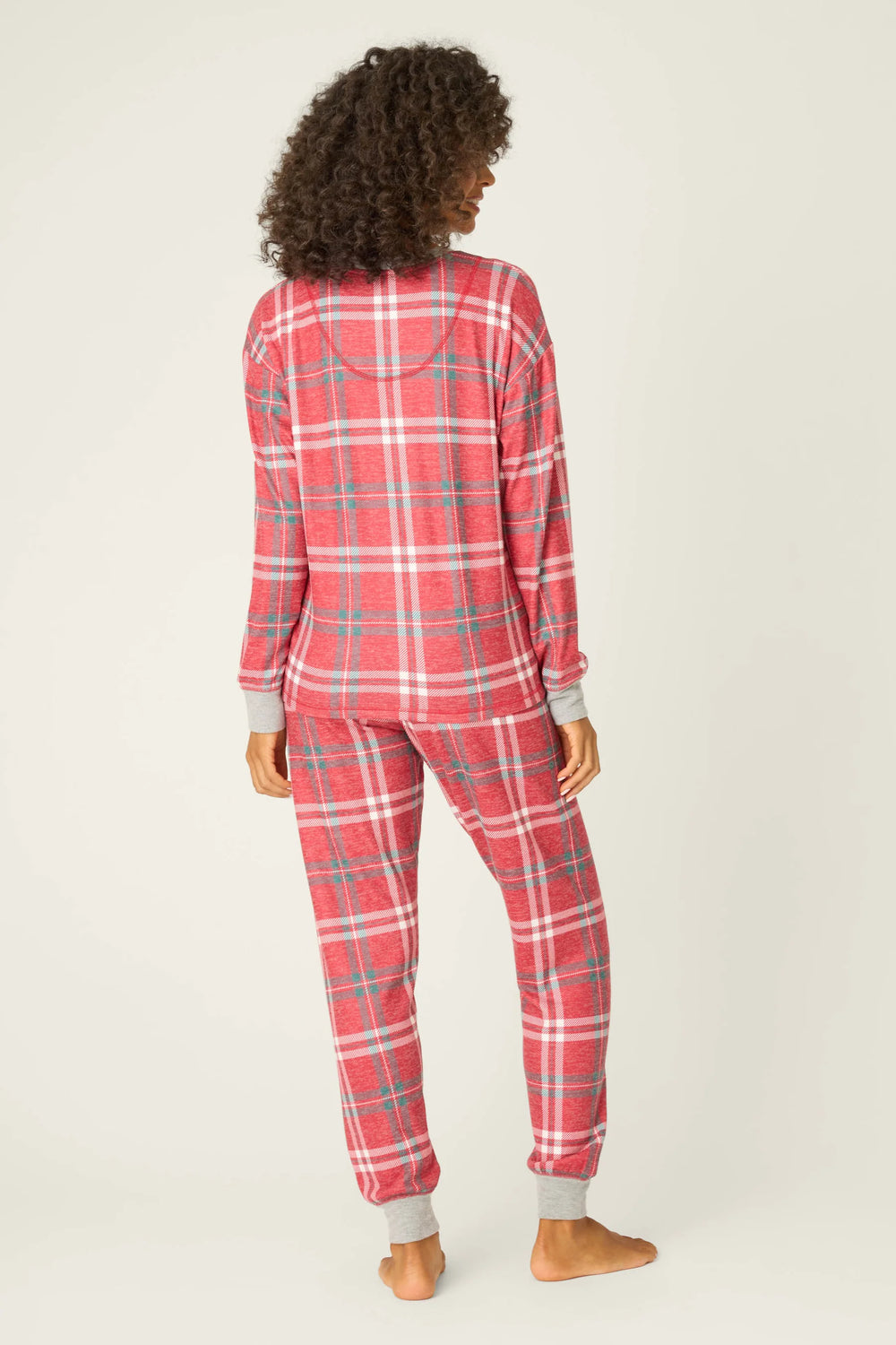 Person wearing red plaid pajamas on a white background