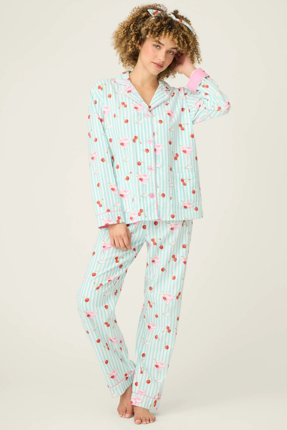 Woman wearing a patterned flannel pajama set on a plain background
