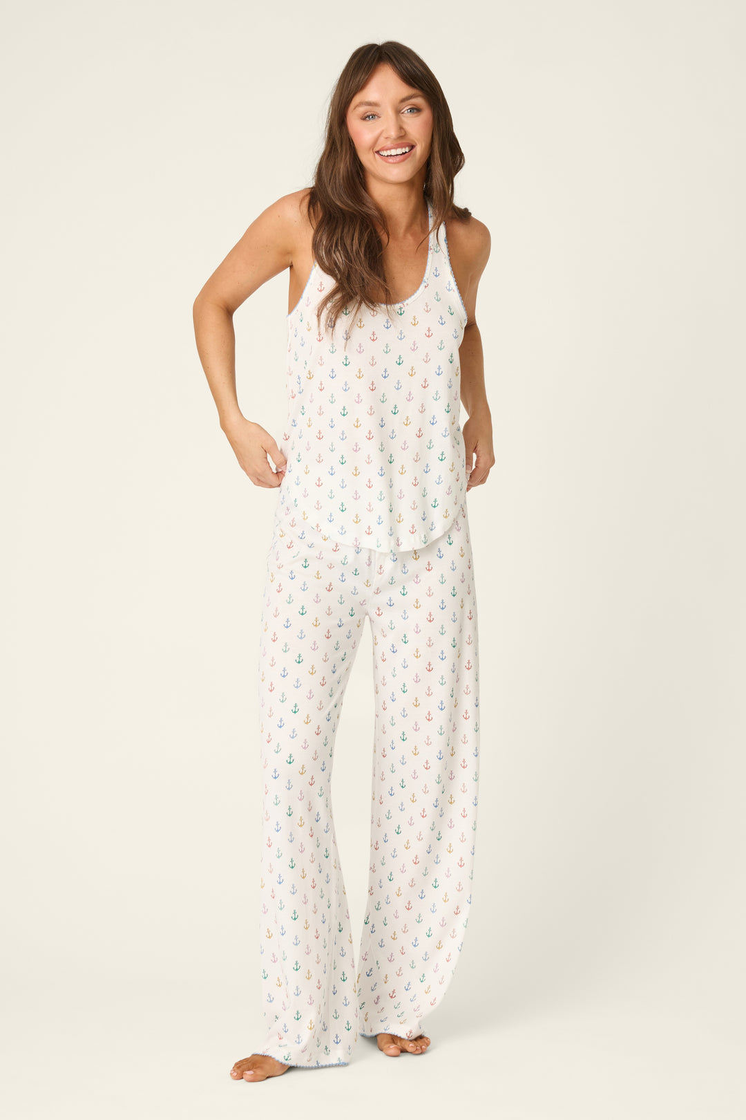 Woman wearing a white natutical pajama set on a white background
