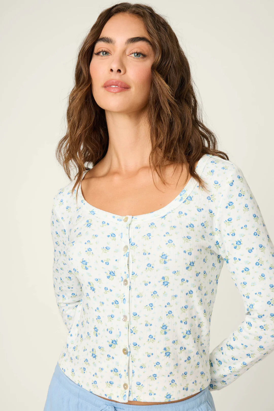 Woman wearing a floral cardigan against a plain background