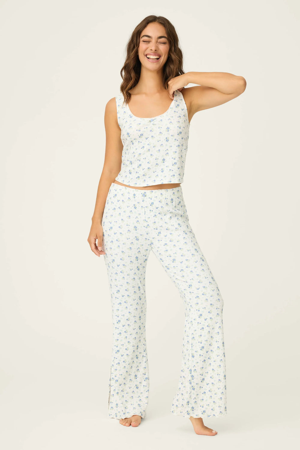 Woman wearing a white floral pajama set on a plain background