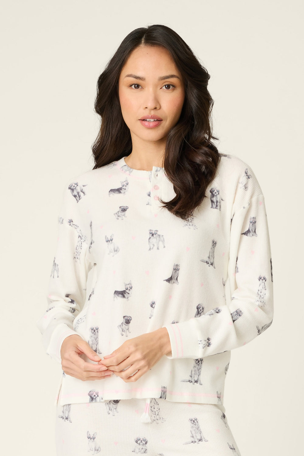 Woman wearing a white sweatshirt with dog print on a plain background