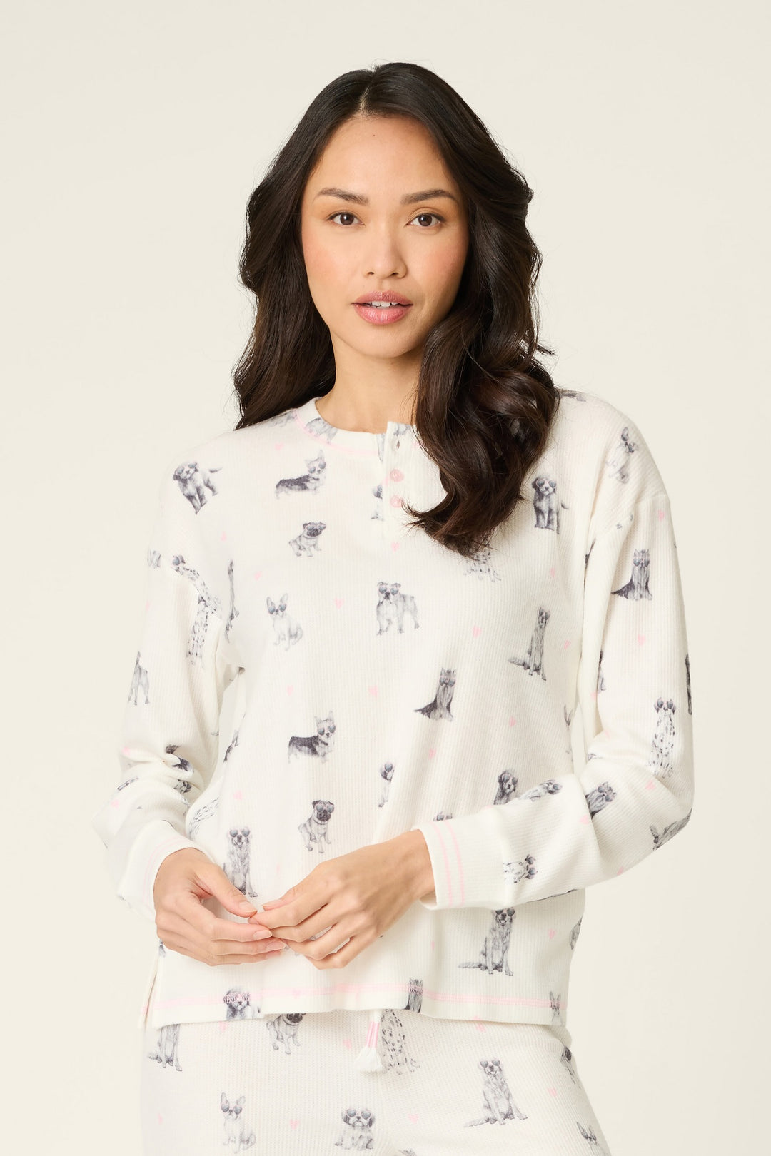 Woman wearing a white sweatshirt with dog print on a plain background