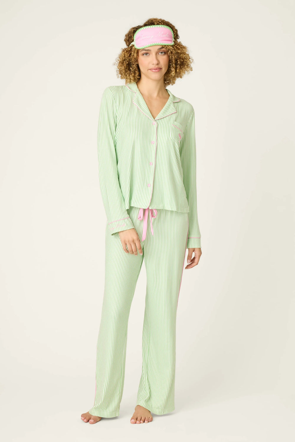Woman wearing a light green pajama set with a matching headband on a white background