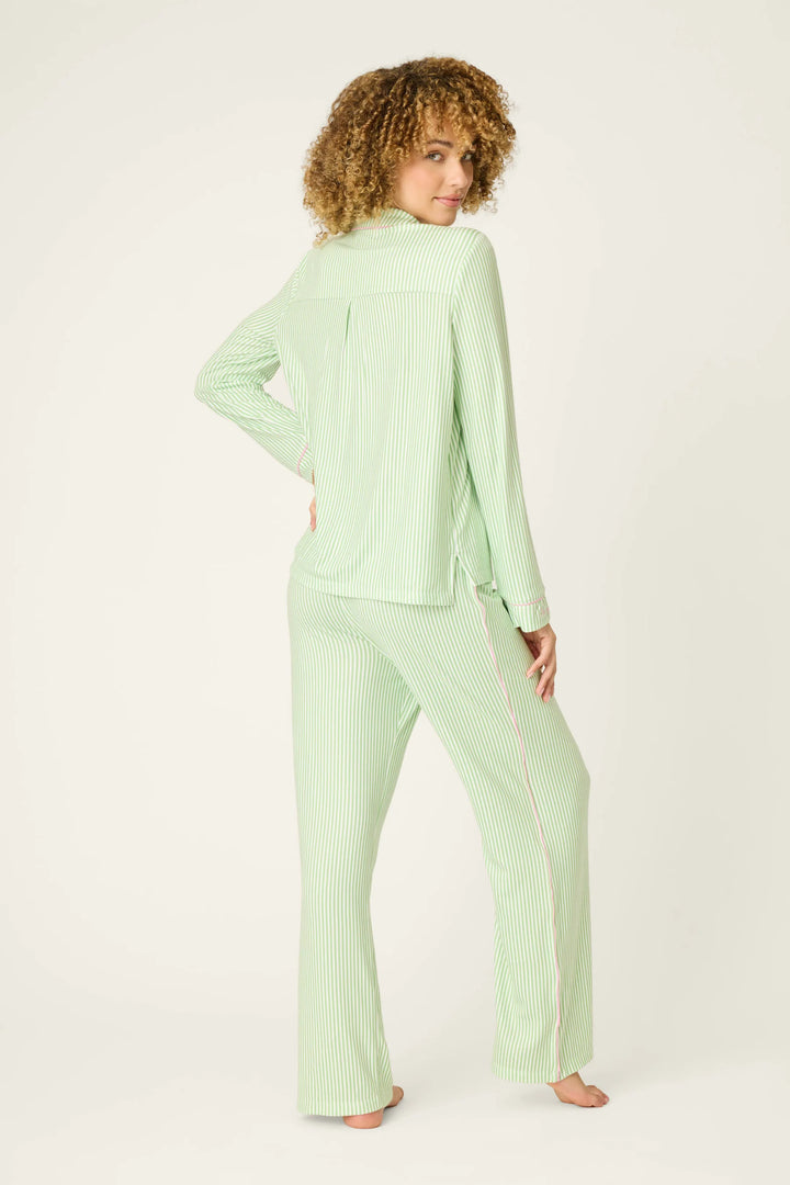 Woman wearing a light green pajama set on a white background