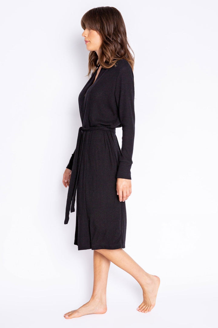Woman wearing a black long-sleeve robe against a white background