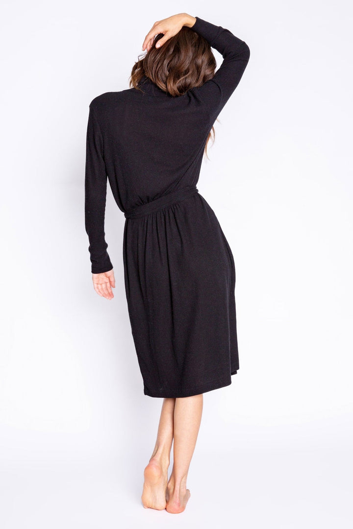 Woman wearing a black robe with long sleeves on a white background