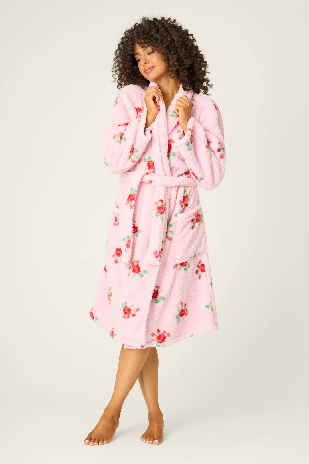 Woman wearing a pink floral robe on a white background